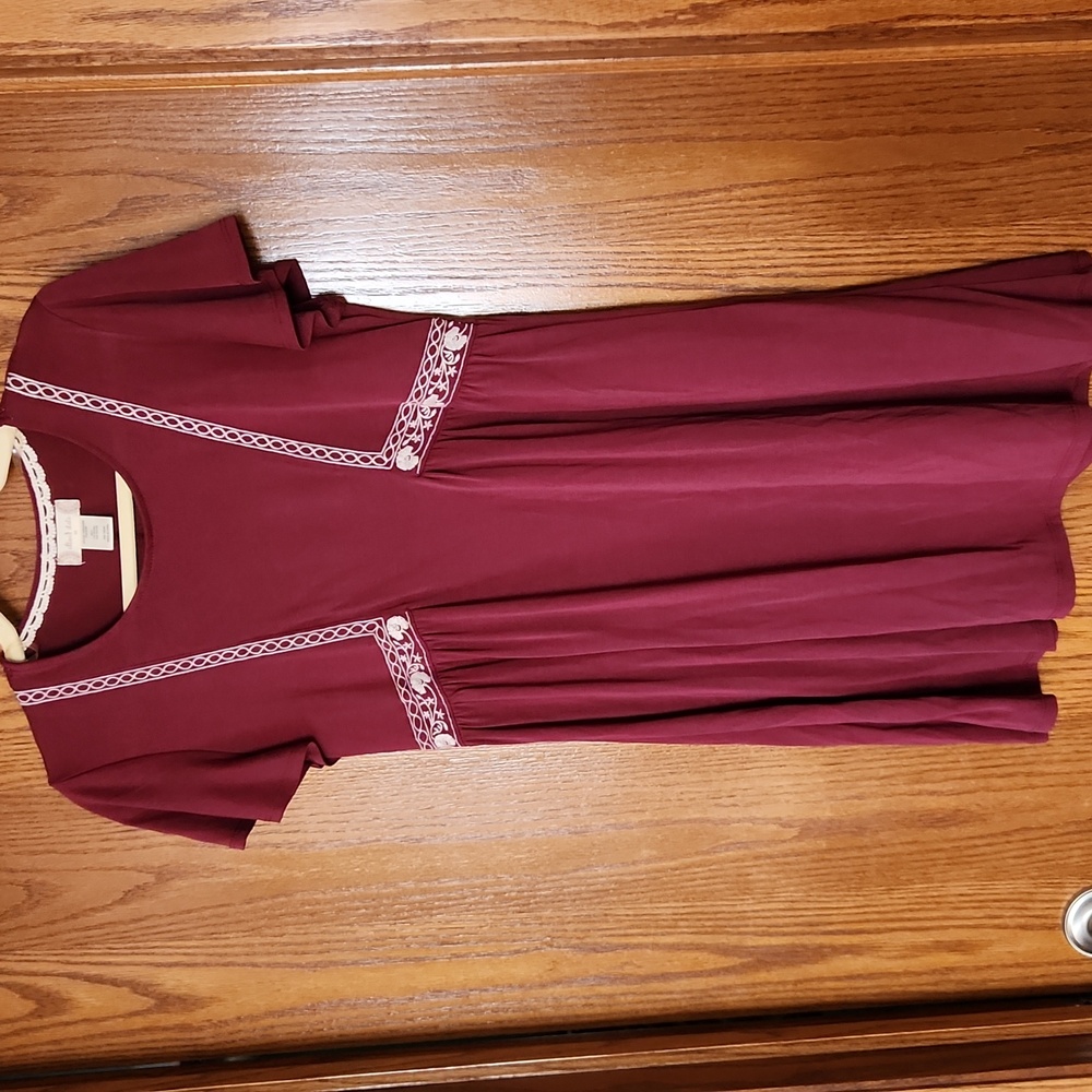 Comfortable maroon dress with embroidered accents.